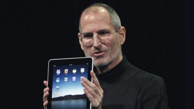 Steve Jobs segura um iPad em evento de apresentação da Apple