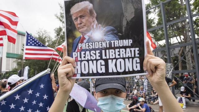香港抗议者游行示威时举着标语，呼吁美国总统特朗普"解放香港"。