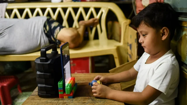 Seorang bocah menatap layar gawai di rumah saat masa pandemi Covid-19.