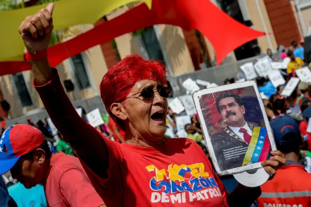 Una mujer con un retrato de Maduro