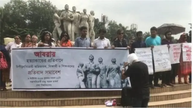 ঢাকা বিশ্ববিদ্যালয়ের রাজু ভাস্কর্য প্রাঙ্গণে বিশ্ববিদ্যালয়ের শিক্ষার্থী এবং শিক্ষকরা বিক্ষোভ করছে