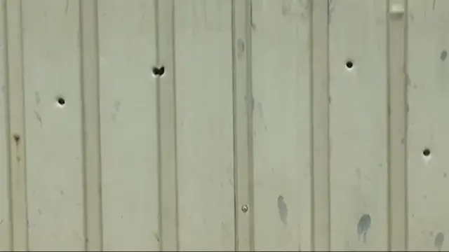 சுதேஷ் வீட்டின் மீது நடந்த துப்பாக்கிச் சூட்டில் அவரது வீட்டு கேட்டில் ஏற்பட்ட துளைகள்.