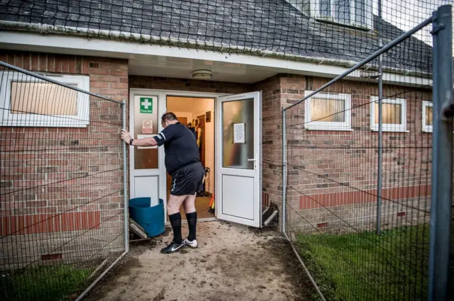 A linesman cleans his boots
