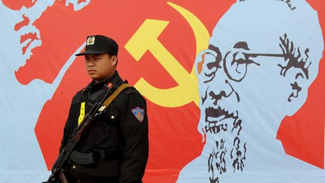 一名警卫站在胡志明画像前