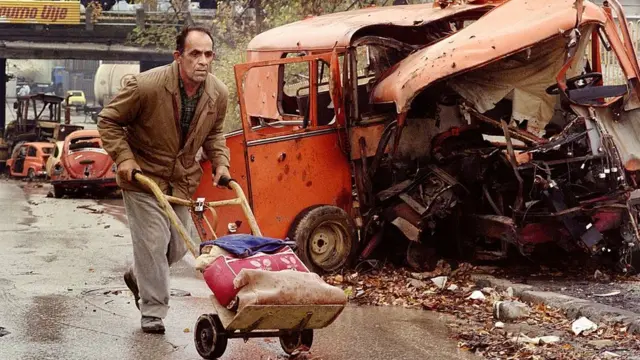 یکی از اهالی سارایوو در حال فرار از تک‌تیراندازان در میانه جنگ