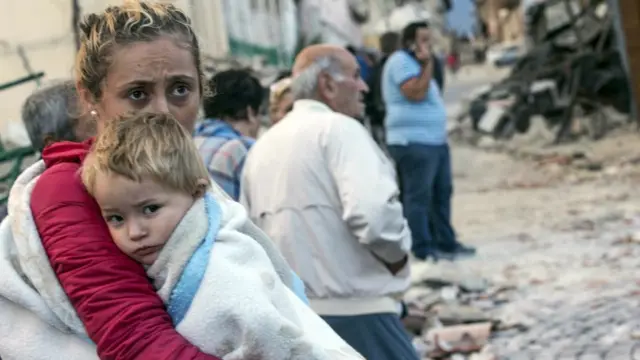 A woman holds a child in Amatrice (24 August)