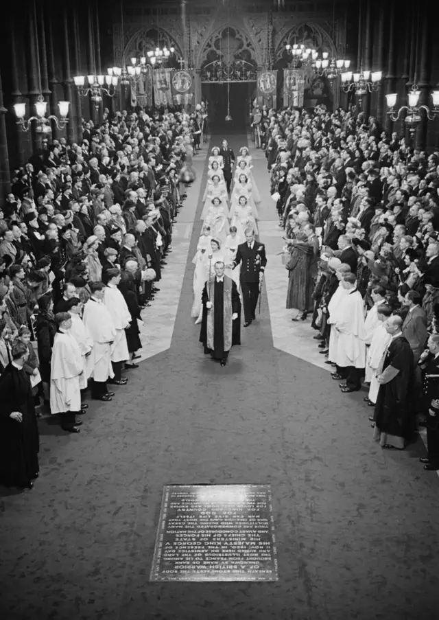 La princesa Isabel (más tarde la reina Isabel II) y Felipe Mountbatten (luego el príncipe Felipe) caminan por el pasillo de la Abadía de Westminster, en Londres, el día de su boda, el 20 de noviembre de 1947.