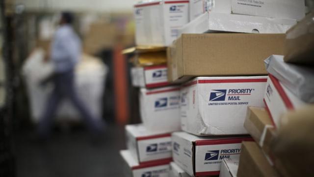 A United States Postal Service employee sorts packages at the Lincoln Park Carriers Annex in Chicago, November 29, 2012.