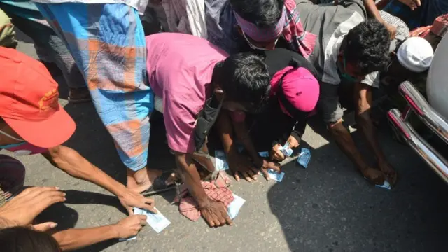 টাকা কুড়িয়ে নিতে হুড়োহুড়ি।