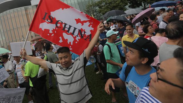 香港添马公园亲政府集会上一名男子举起“香港是中国的”标语（17/8/2019）