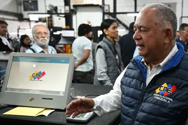 Amoroso al lado de una máquina para votar. 