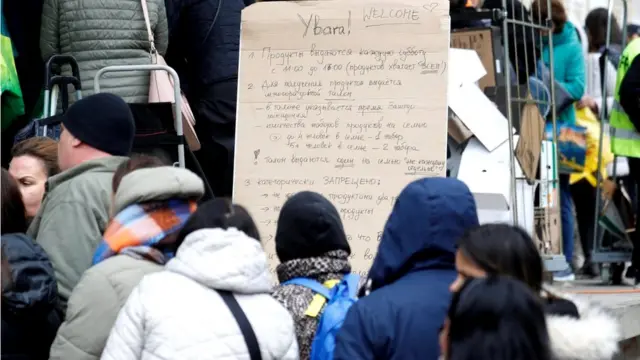 A sign points Ukrainian refugees in the direction of a food distribution centre in Zurich, Switzerland, 23 April 2022
