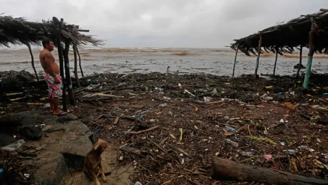 Residente observa destruição causada pela tempestade.