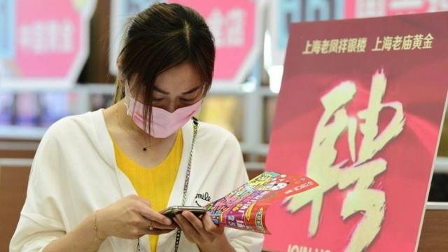 Mulher verifica informações em seu telefone durante uma feira de empregos na cidade de Hai'an, província de Jiangsu, China, em maio de 2020