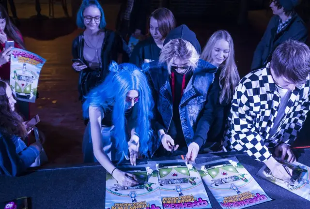 Группа "Френдзона" подписывает афиши для расстроенных из-за отмены концерта фанатов