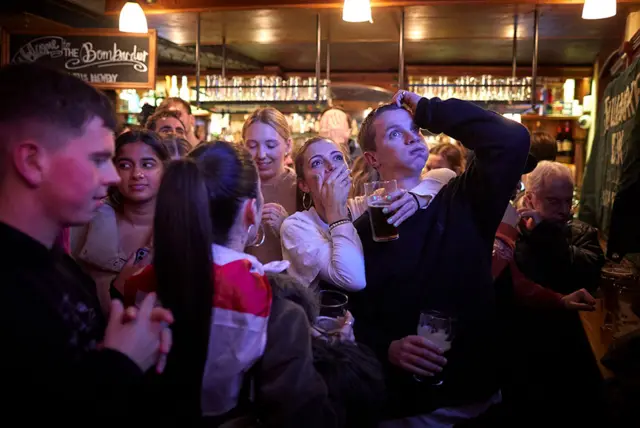 رد فعل مشجعي كرة القدم الإنجليزية على ركلة الجزاء الضائعة من هاري كين وهم يشاهدون مباراة ربع نهائي كأس العالم بين فرنسا وإنجلترا في بار بومباردييه بار في باريس.