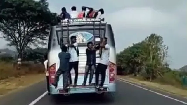 தொங்கியபடி செல்லும் மாணவர்கள்.