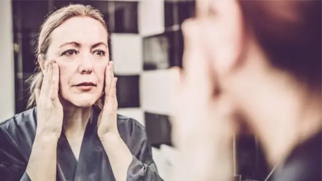 દર્પણમાં જોતી મહિલા.