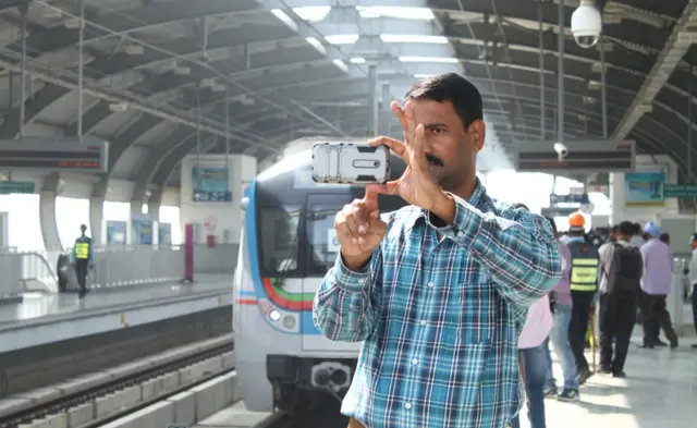 మెట్రో స్టేషన్లో ఫొటో తీసుకొంటున్న ఒక ప్రయాణికుడు