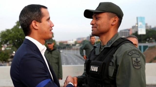 Venezuelan opposition leader Juan Guaido, who many nations have recognised as the country"s rightful interim ruler, shakes hands with a military member near the Generalisimo Francisco de Miranda Airbase "La Carlota", in Caracas, Venezuela April 30, 2019.