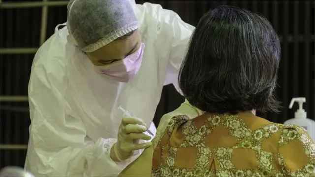 A medical worker administers a jab of Vaxzevria (formerly AstraZeneca) COVID-19 vaccine ahead of the COVID-19 alert Level 3 restriction lift in Taipei