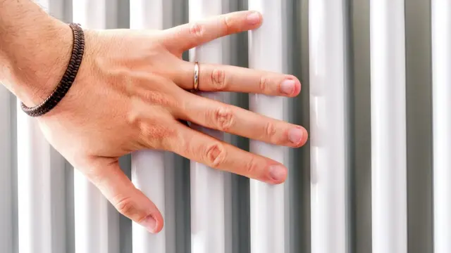 a hand touches a radiator