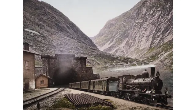 Un tren de vapor saliendo de un túnel, en medio de las montañas suizas, foto tomada en 1901. Swiss Cameera Museum Collections