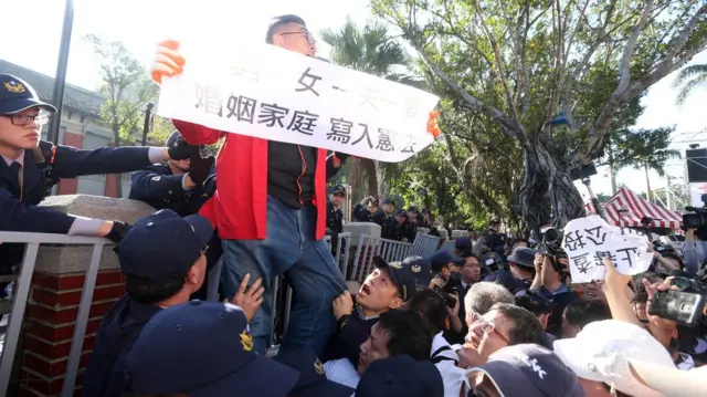 反同婚民眾手持標語，試圖進入立法院，與警方發生推擠。（台灣中央社圖片26/12/2016）