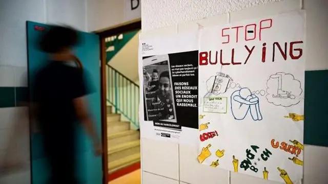 Seorang pelaar melewati selebaran berupa kampanye agar menghentikan tindakan bullying di sekolah. 