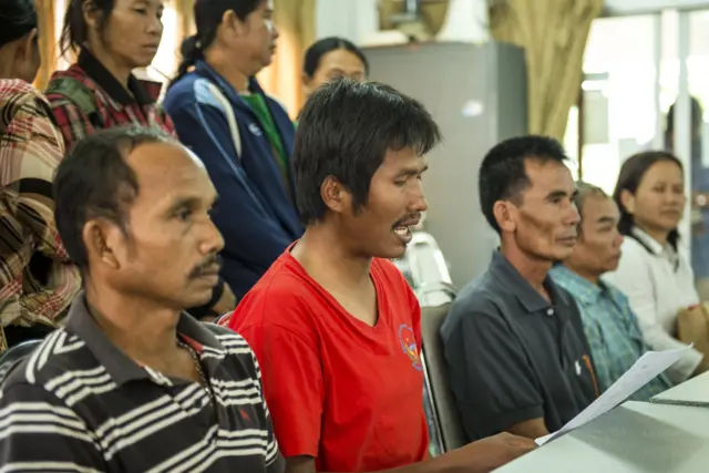 นายไพโรจน์ (ใส่เสื้อสีแดง) อ่านแถลงการณ์เรียกร้องให้ คสช. หยุดทวงคืนผืนป่า