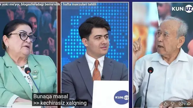 Markazda tok shou boshlovchisi, chapda yashil kostyum kiygan, ko‘z oynak taqqan yoshi katta ayol kishi, o‘ngda keksa erkak barmog‘ini tepaga ko‘tarib gapiryapti