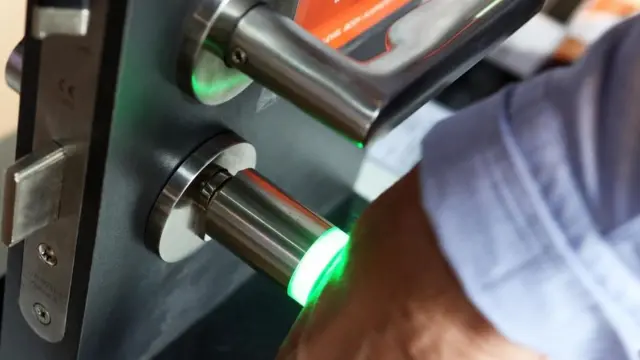 Una persona poniendo su brazo contra un lector de microchips