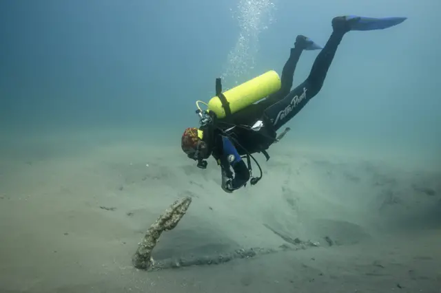 Roberto Junco frente a una de las anclas encontradas.