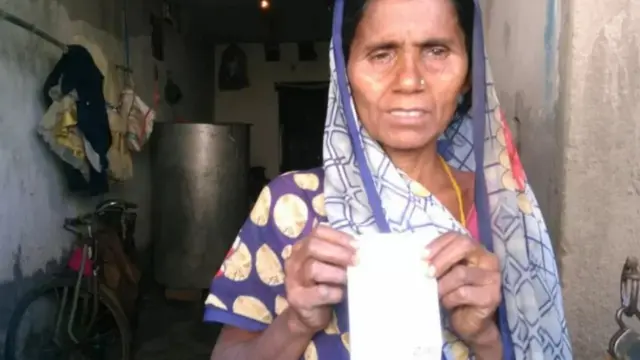 சிறுமியின் ஆதார் அட்டையை காட்டும் தாய் நிஷா தேவி