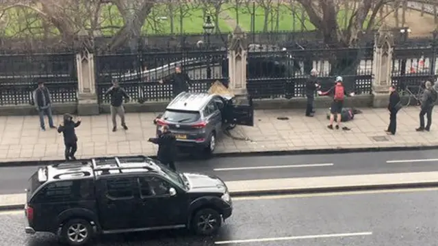 Watu wakiwa karibu na gari lililogongeshwa kwenye ua