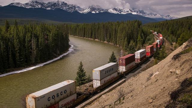 A Canadian Pacific Railway freight train makes its way westward along the Bow River
