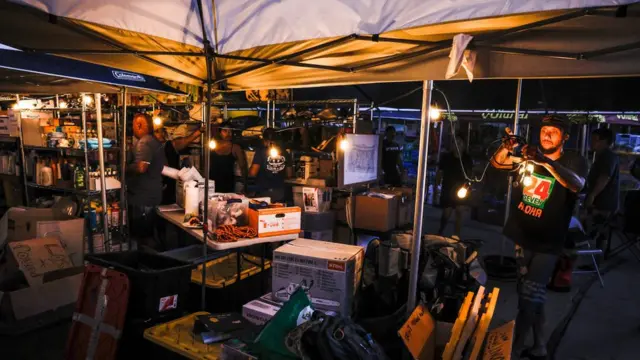 خيمة أمام أحد المنازل تستخدم كمركز لتوزيع المواد الغذائية والمساعدات لضحايا حرائق الغابات