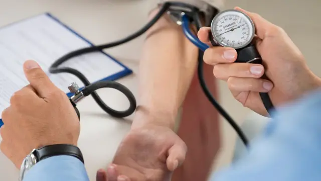 Cardiólogo toma la presión arterial