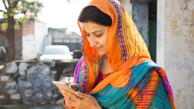 ਸਿਰ 'ਤੇ ਦੁਪੱਟਾ ਲਈ ਮੋਬਾਈਲ ਫੋਨ ਦੇਖ ਰਹੀ ਮਹਿਲਾ