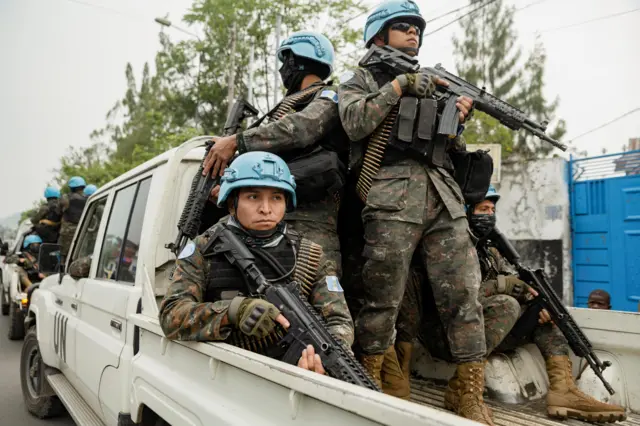 د کانګو دیموکراتیک جمهوریت (MONUSCO) کې د ملګرو ملتونو د سازمان د ثبات ماموریت غړي په یوه پیک اپ کې سپاره دي ځکه چې دوی د ملګرو ملتونو غیر ضروري کارمندانو ایستل خوندي کوي