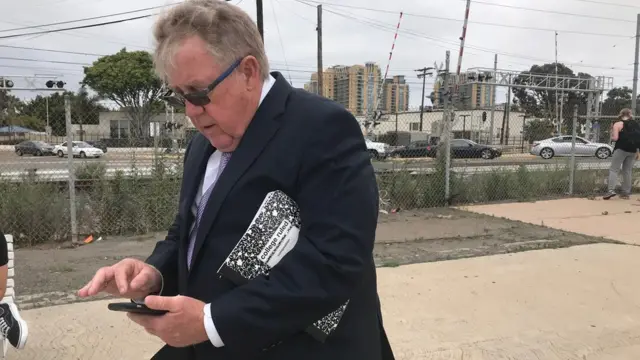 El padre de Edward Gallagher, mirando su teléfono.