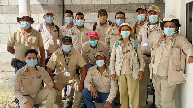 Monroy con integrantes de su equipo con mascarilla devido al covid