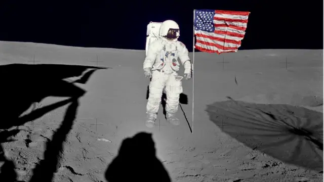 O astronauta Edgar D. Mitchell ao lado da bandeira americana na Lua