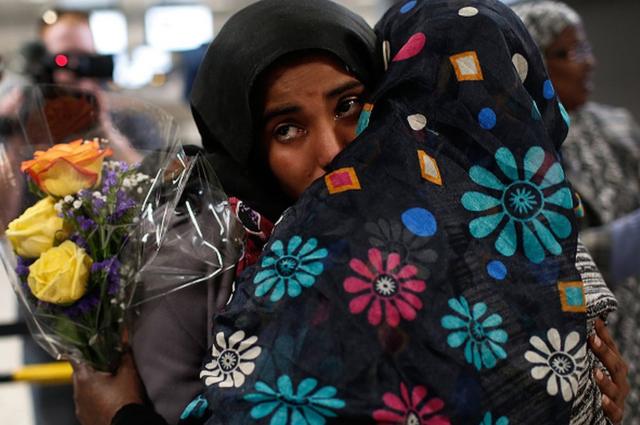 大統領令の執行を下級審が差し止めたことで、入国が認められたイエメン人の女性を家族が歓迎した（2月、バージニア州の空港で）