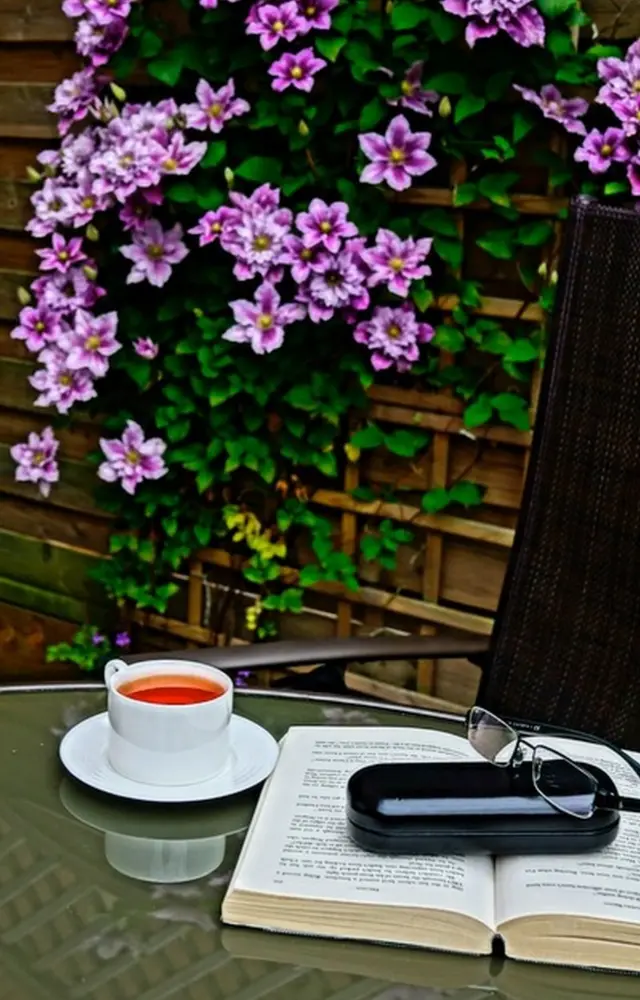 Una mesa de jardín con un libro y una taza de té.