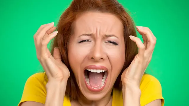 Mujer desesperada tapándose los oídos