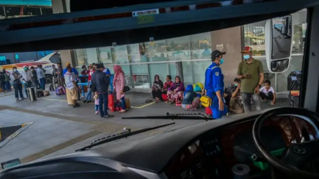 Calon penumpang menunggu jadwal keberangkatan bus di Terminal Terpadu Pulo Gebang, Jakarta, Jumat (26/03)