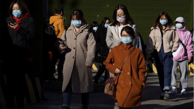 People walk in a street during morning rush hour following an outbreak of the coronavirus disease (COVID-19) in Beijing, China, November 3, 2020.
