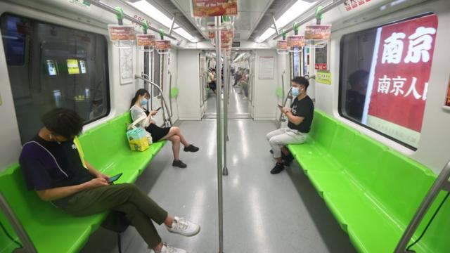 中國江蘇南京地鐵上乘客戴著口罩出行（中新社圖片27/7/2021）