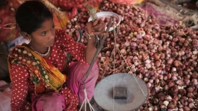 ঢাকার একটি বাজারে পেঁয়াজ বিক্রি করছেন এক বিক্রেতা